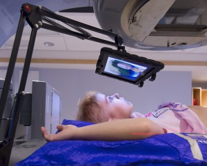 Picture of a child receiving radiation treatment while watching an ipad (no anaesthesia necessary!) 